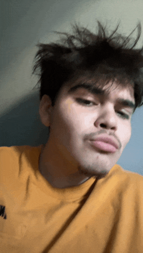 a man wearing a yellow t-shirt with the word s on it