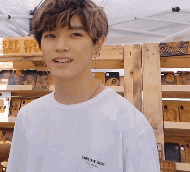 a young man wearing a white shirt that says save the late on it