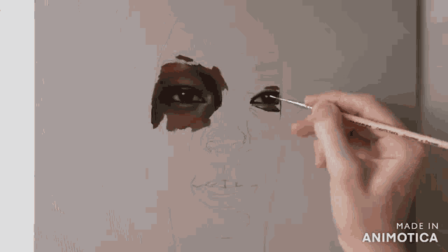 a person is painting a woman 's face with a brush and the words made in animatica are visible