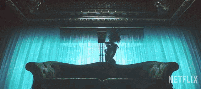 a silhouette of a woman on a couch with netflix written on the bottom