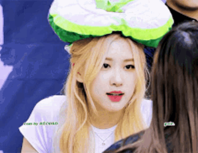 a woman with blonde hair wearing a green and white hat
