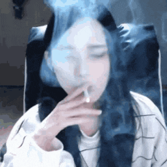 a woman is smoking a cigarette in a chair .