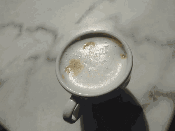 a cup of coffee with a heart shaped foam on the top