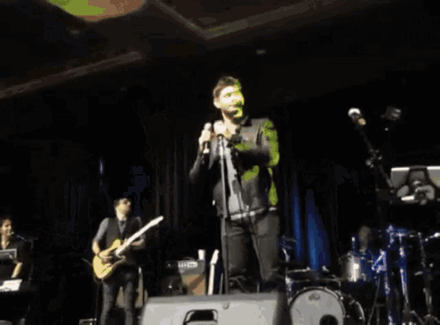 a man singing into a microphone on stage
