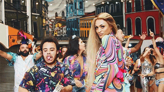 a group of people are dancing in a street with a woman in a colorful dress .
