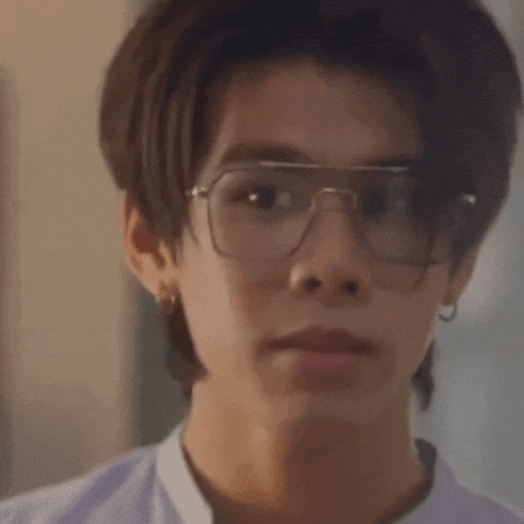 a close up of a man wearing glasses and earrings .