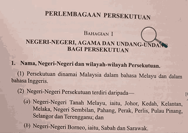 a magnifying glass is on top of a paper that says negeri-negeri agama dan undang-undang bagi persekutuan