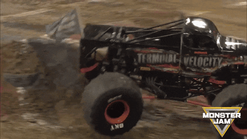 a monster jam truck is driving through a muddy field