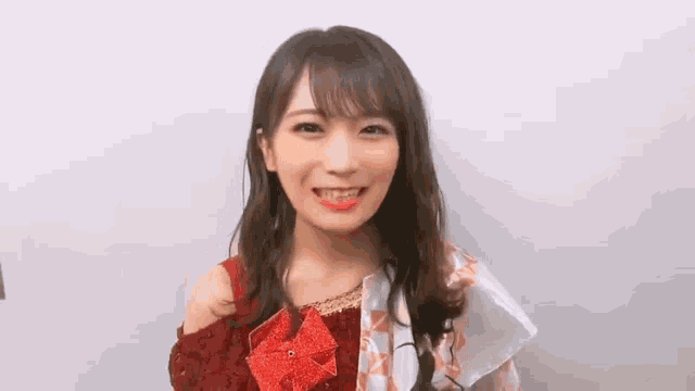 a young woman is wearing a red top and a red pinwheel around her neck .