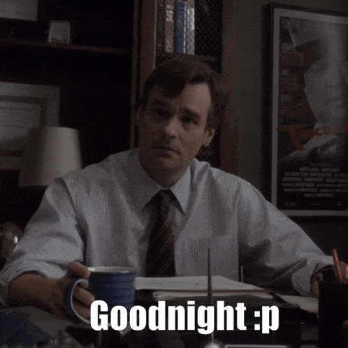 a man sitting at a desk with a cup of coffee and the words goodnight : p written on the screen
