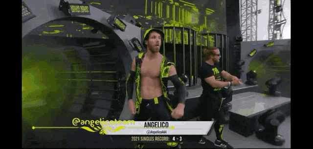 a wrestler named angelico is standing on a stage with his hands in the air