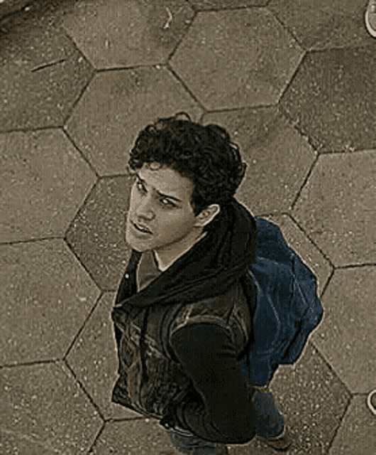 a man wearing a black vest and a blue backpack