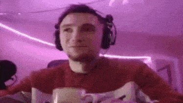 a man wearing headphones is sitting at a table with a cup of coffee and a microphone .