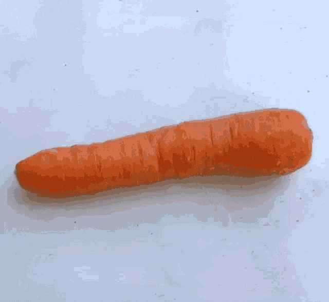 a carrot is sitting on a white surface with a black border