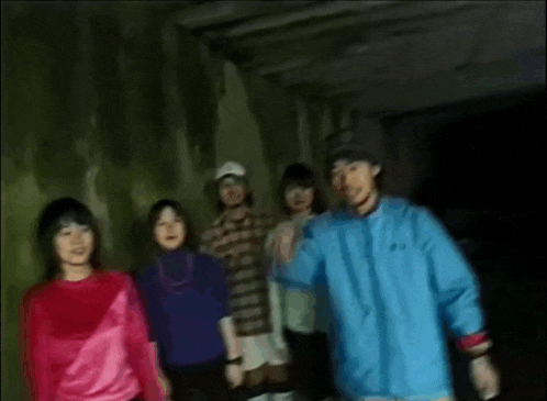 a group of people are posing for a picture in a tunnel