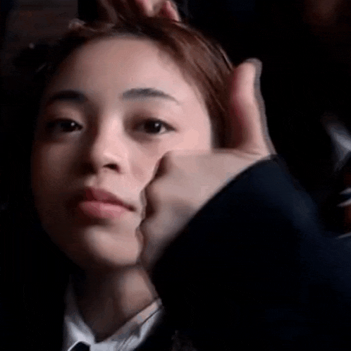 a close up of a woman making a silly face with her finger in her mouth .