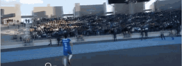 a soccer player wearing a number 11 jersey is running on the field