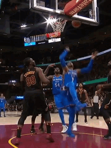 a basketball player with the number 99 on his jersey is trying to block a shot