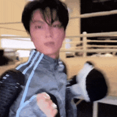 a man wearing boxing gloves is holding a stuffed panda bear