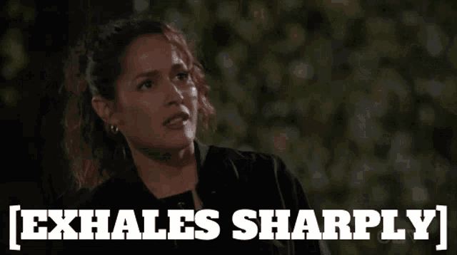 a woman says exhales sharply in front of a blurred background