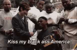 a group of men are standing around a man with the words kiss my black ass america written on the bottom