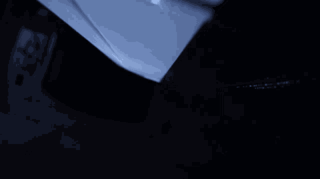 a dark room with a blue light shining on a corner