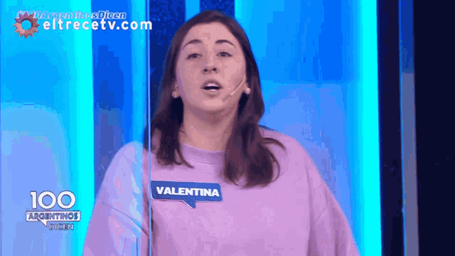 a woman in a purple sweater has a name tag that says " valentina "