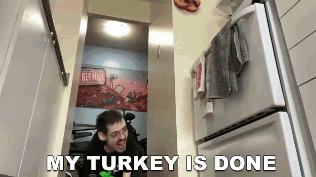 a man sitting in front of a refrigerator with the words my turkey is done below him