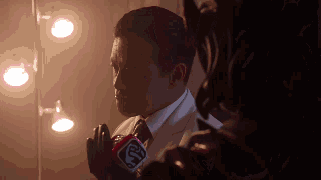 a man in a suit and tie is holding a microphone that says cbs