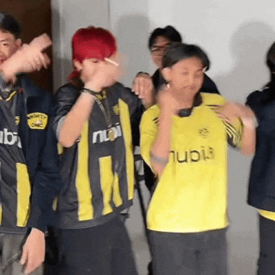 a group of people are dancing and one of them is wearing a yellow shirt with the word nubi on it