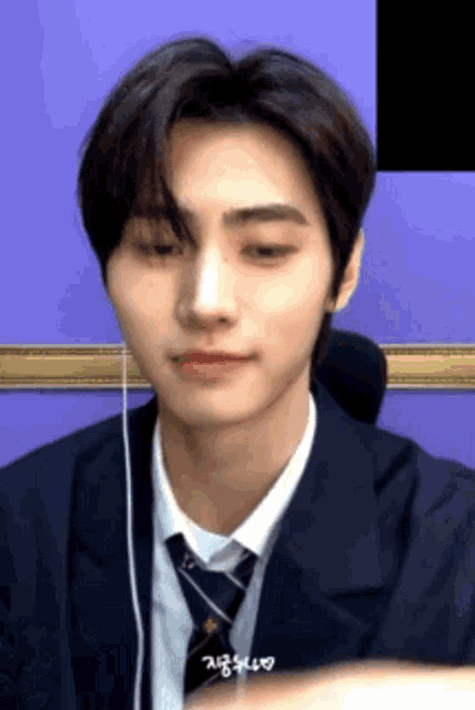 a young man wearing a suit and tie with headphones on