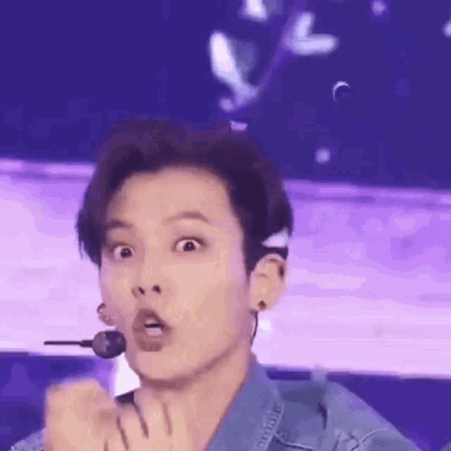 a close up of a person making a funny face while wearing a microphone .