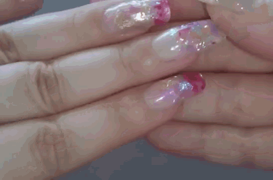 a close up of a woman 's nails with a floral design on them
