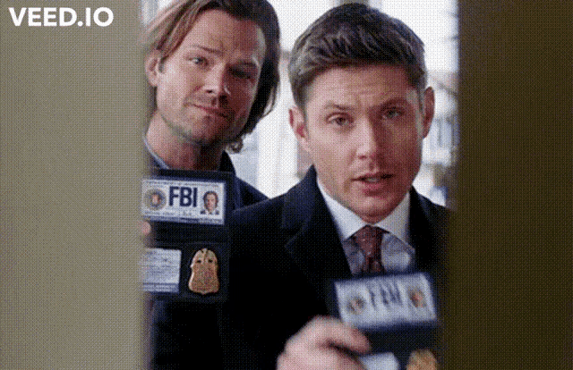 two men are standing next to each other holding badges that say fbi