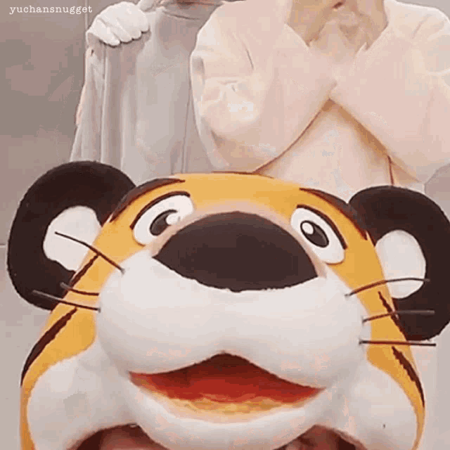 a person wearing a tiger mascot costume is standing next to another person wearing a tiger mascot costume .