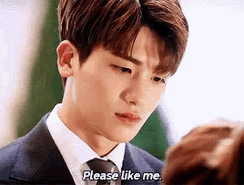a man in a suit and tie is talking to a woman and asking her if she likes him .
