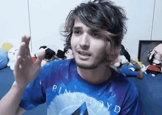 a man wearing a blue pink floyd shirt is talking