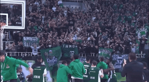 a basketball game is being played in front of a crowd with a banner that says athens