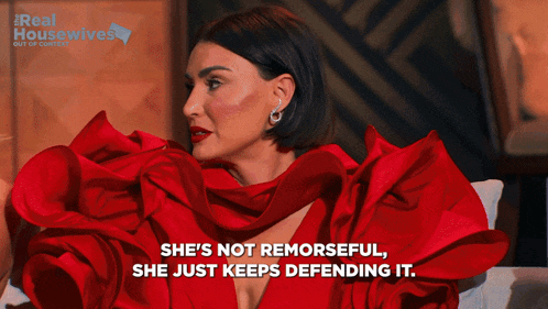 a woman in a red dress with the words she 's not remorseful she just keeps defending it