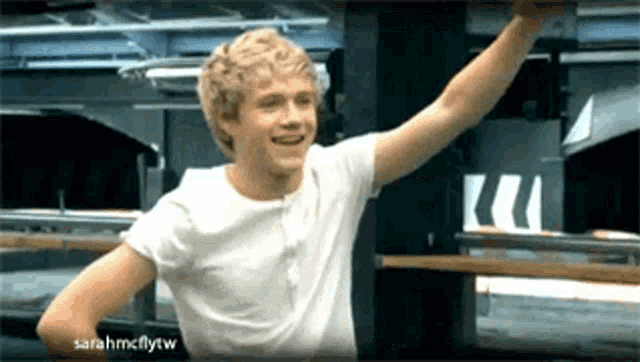 a young man in a white shirt is smiling with sarahmcflytw written in the corner