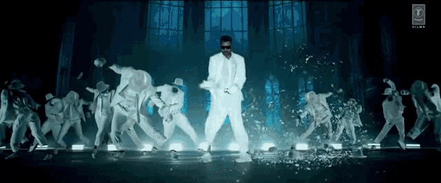a man in a white suit is dancing with a group of dancers