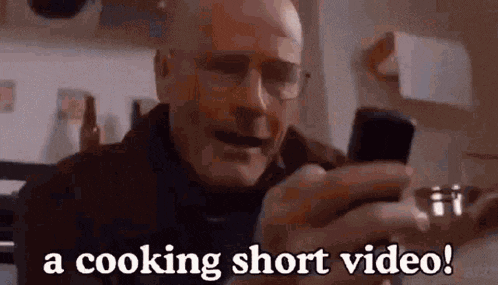an older man is holding a cell phone in his hand and says `` a cooking short video ! ''