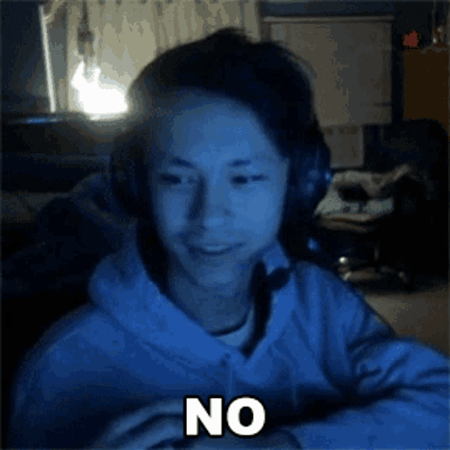 a man wearing headphones and a white hoodie says no