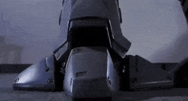 a close up of a robot 's legs standing on a concrete floor .