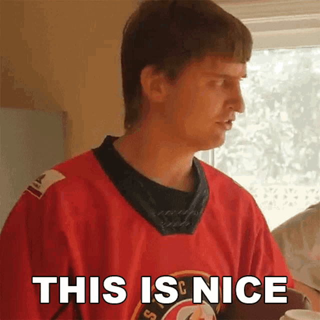 a man wearing a red jersey with the words this is nice written on it