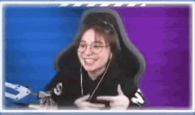 a woman wearing glasses and headphones is sitting in a chair .