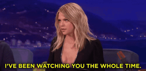a woman in a black dress is sitting in a chair and saying i 've been watching you the whole time