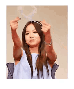a woman in a blue dress is making a middle finger gesture with her hands .