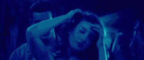 a man and a woman are dancing together in a dark room in a club .