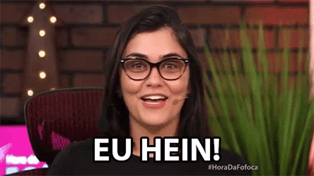 a woman wearing glasses is smiling and says eu hein